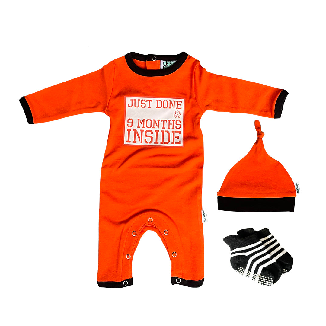 Orange baby grow with Just Done 9 Months Inside slogan, matching orange mat and black and white stripy socks