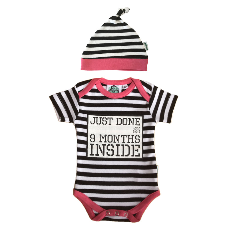 Black and white stripy vest with pink edging trim with slogan Just Done 9 Months Inside. Matching stripy hat.
