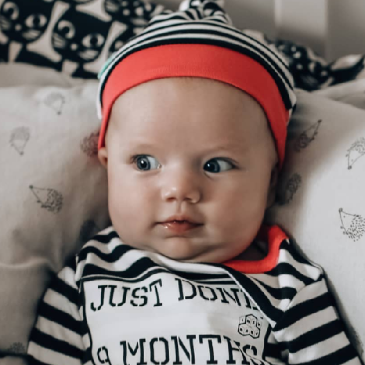 Baby girl wearing Just Done 9 Months Inside pink trim baby grow and matching hat