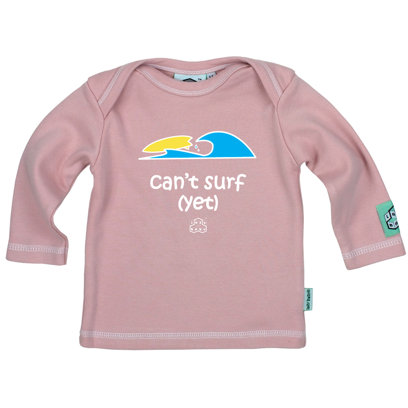 light pink long sleeve tee featuring can't surf yet slogan and picture of surfboard riding wave