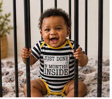 Baby in a striped Just Done 9 Months Inside vest, sitting behind cot bars